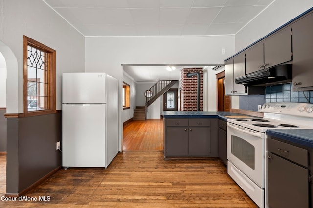 kitchen featuring gray cabinetry, white appliances, dark countertops, and under cabinet range hood