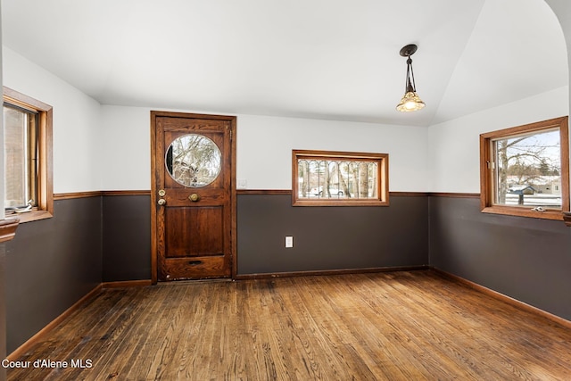 foyer entrance with lofted ceiling, baseboards, and dark wood finished floors