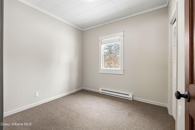 carpeted empty room with baseboards, crown molding, and baseboard heating