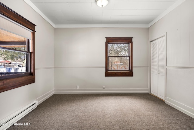 carpeted empty room with a baseboard radiator, baseboards, and crown molding