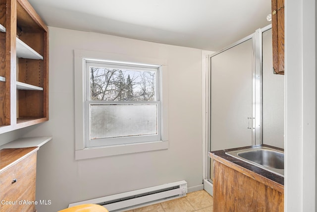 interior space with a shower with shower door and baseboards