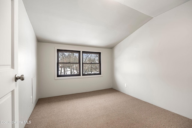 spare room with vaulted ceiling and carpet floors