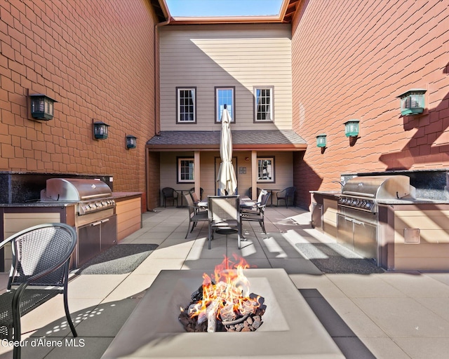 view of patio with a fire pit, a grill, and an outdoor kitchen