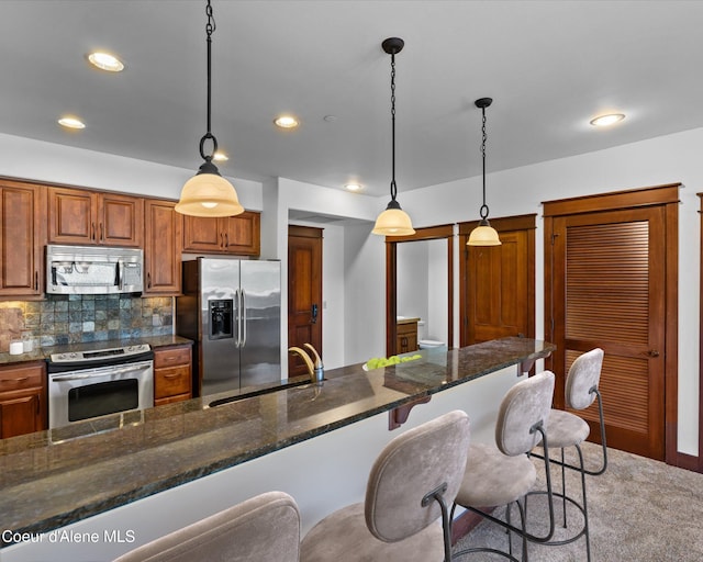 kitchen featuring sink, stainless steel appliances, decorative light fixtures, and decorative backsplash