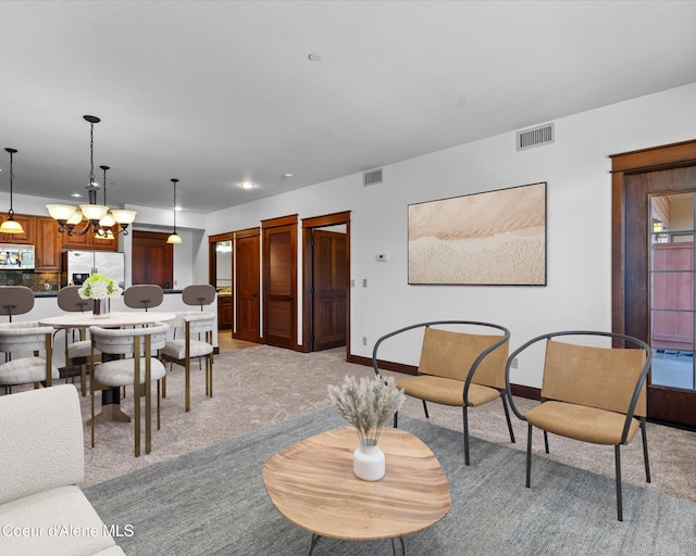 carpeted living room with a chandelier