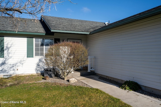 view of exterior entry featuring a lawn