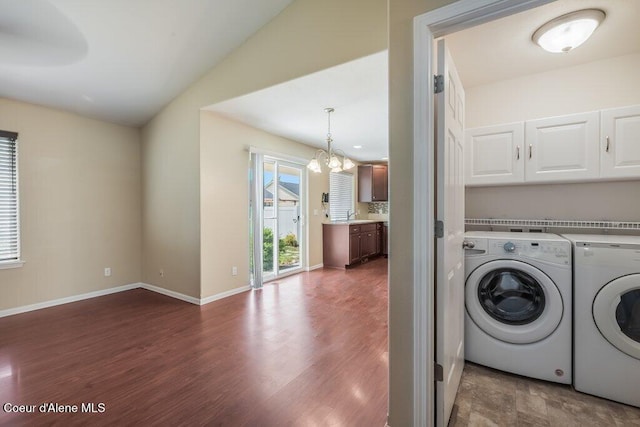 1449 N Moonstone St, Post Falls, ID 83854 - washroom featuring washer and clothes dryer, a chandelier, dark wood-style flooring, and cabinet space