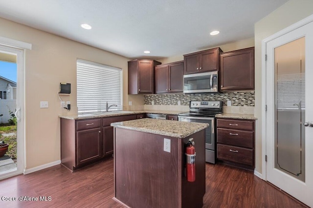 1449 N Moonstone St, Post Falls, ID 83854 - kitchen featuring appliances with stainless steel finishes, dark wood finished floors, decorative backsplash, a center island, and recessed lighting
