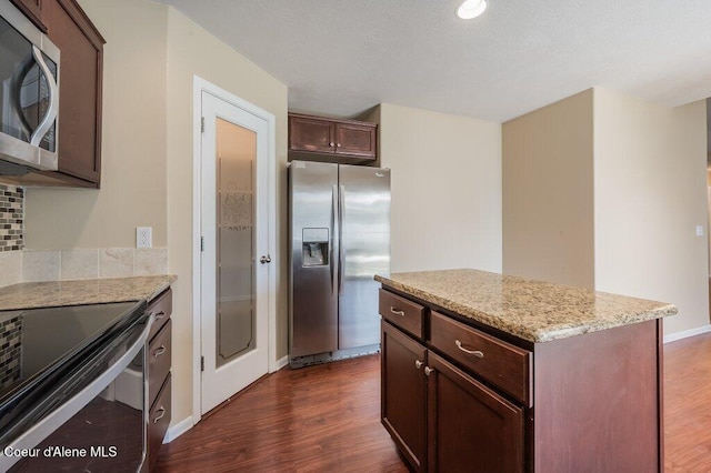 1449 N Moonstone St, Post Falls, ID 83854 - kitchen with stainless steel appliances, dark wood-style floors, a kitchen island, and tasteful backsplash