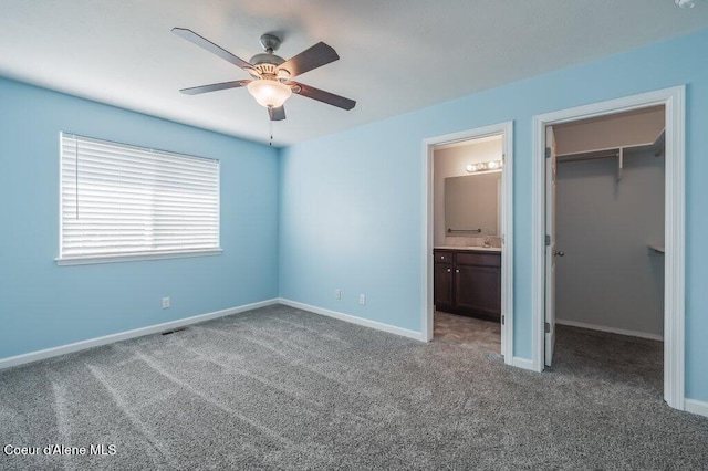 1449 N Moonstone St, Post Falls, ID 83854 - unfurnished bedroom with a walk in closet, carpet, connected bathroom, a closet, and ceiling fan