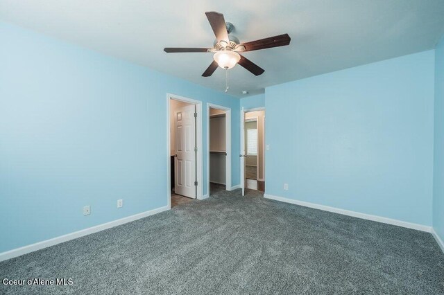 1449 N Moonstone St, Post Falls, ID 83854 - unfurnished bedroom with carpet flooring, a walk in closet, and a ceiling fan