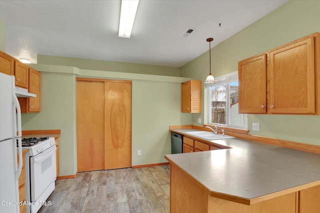 kitchen featuring kitchen peninsula, white appliances, pendant lighting, light hardwood / wood-style flooring, and sink