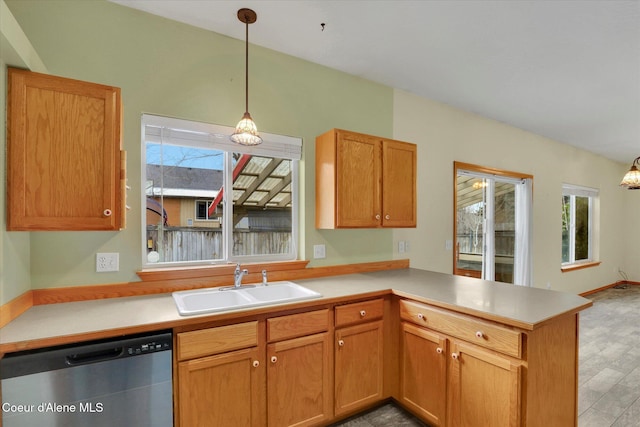 kitchen with stainless steel dishwasher, kitchen peninsula, sink, hanging light fixtures, and plenty of natural light