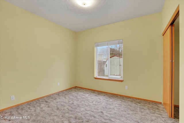 unfurnished bedroom with carpet, a closet, and a textured ceiling