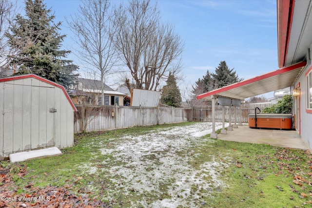 view of yard featuring a patio area, a hot tub, and a storage shed