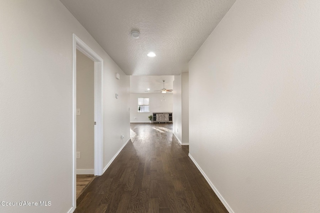 hall featuring dark wood-type flooring and a textured ceiling