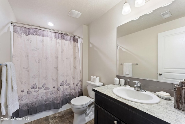 bathroom featuring vanity, toilet, and a textured ceiling