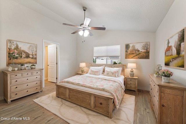 bedroom featuring ensuite bathroom, light hardwood / wood-style flooring, ceiling fan, and lofted ceiling