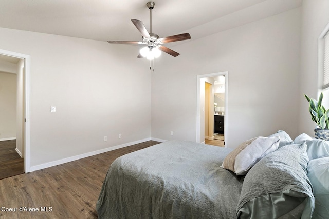 bedroom with dark hardwood / wood-style flooring, vaulted ceiling, ceiling fan, and connected bathroom