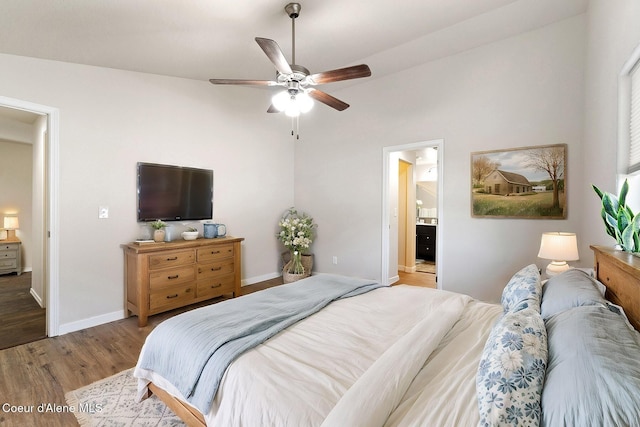 bedroom featuring ensuite bath, ceiling fan, light hardwood / wood-style floors, and lofted ceiling