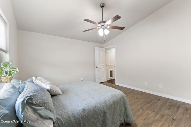 bedroom with vaulted ceiling, ceiling fan, and dark wood-type flooring