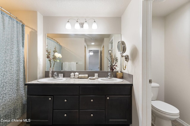 bathroom with vanity, toilet, and a textured ceiling