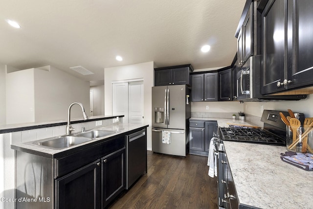 kitchen featuring sink, stainless steel appliances, dark hardwood / wood-style flooring, a textured ceiling, and a kitchen island