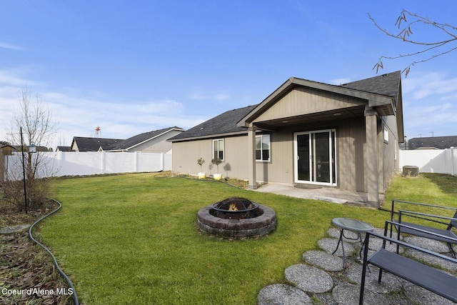 rear view of house featuring central air condition unit, a yard, and a fire pit