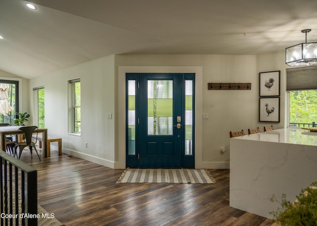 foyer featuring a chandelier, dark wood-type flooring, and lofted ceiling