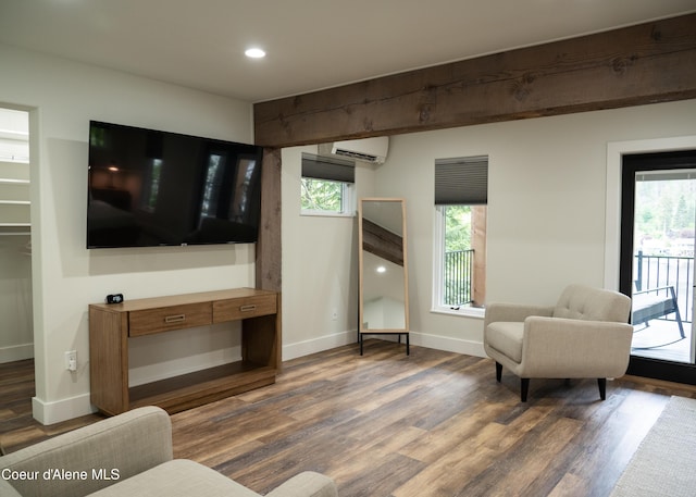 living room with a wall mounted AC and dark wood-type flooring