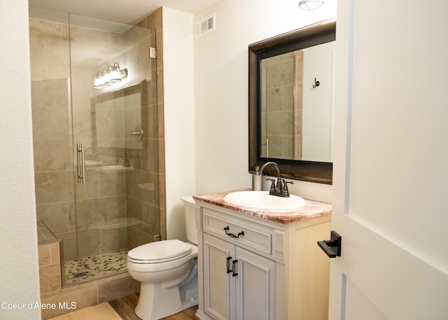 bathroom with hardwood / wood-style flooring, vanity, toilet, and walk in shower