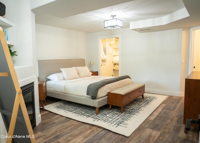 bedroom featuring ensuite bathroom and dark wood-type flooring