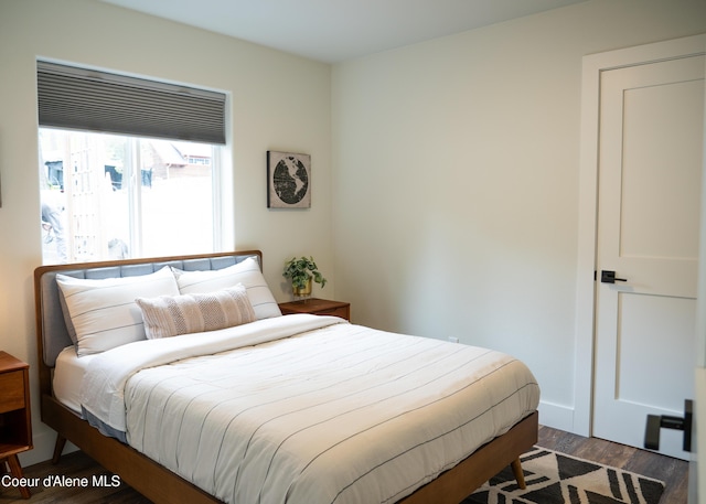 bedroom with dark hardwood / wood-style floors