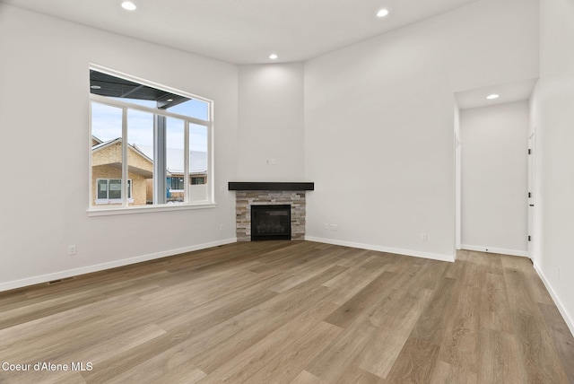 unfurnished living room with a fireplace and light wood-type flooring