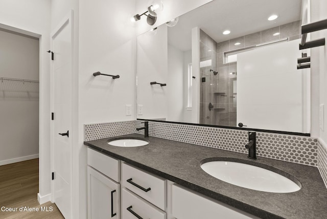 bathroom featuring vanity, backsplash, a shower with shower door, and hardwood / wood-style flooring