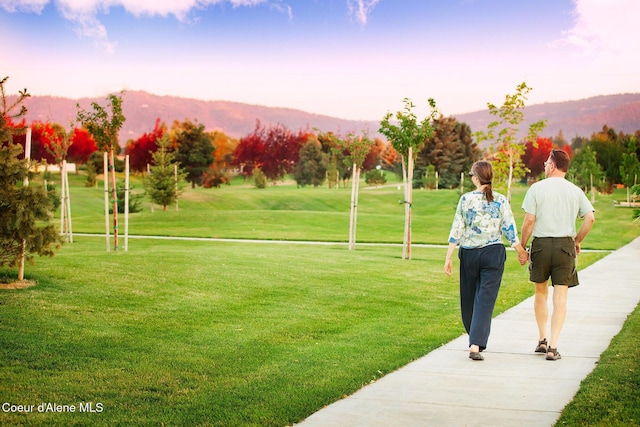 surrounding community with a lawn and a mountain view