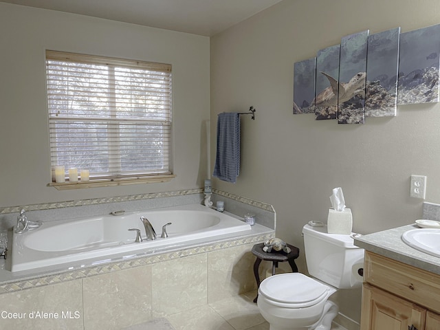 bathroom with tile patterned floors, vanity, a relaxing tiled tub, and toilet