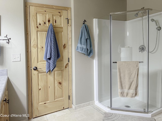 bathroom with tile patterned flooring, vanity, and an enclosed shower