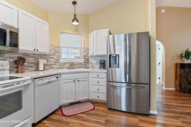 kitchen featuring sink, dark wood-type flooring, appliances with stainless steel finishes, hanging light fixtures, and white cabinets