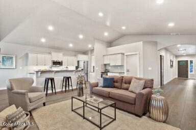 living room featuring light hardwood / wood-style floors and vaulted ceiling