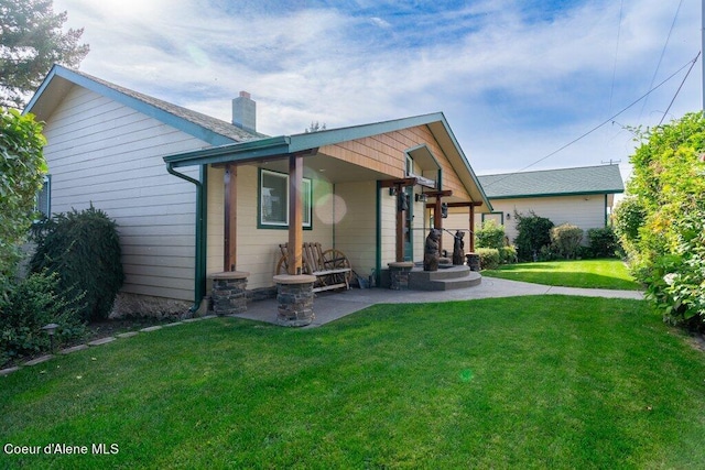 rear view of house with a patio area and a lawn