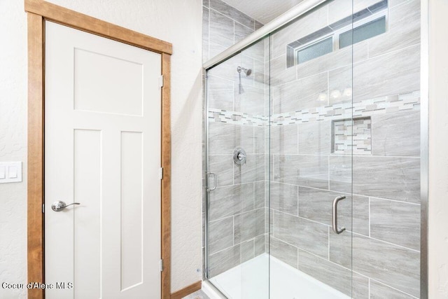 bathroom featuring a shower with door