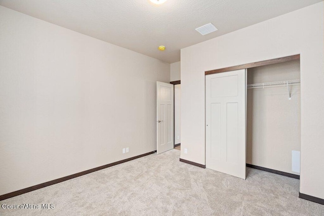 unfurnished bedroom with a closet and light carpet