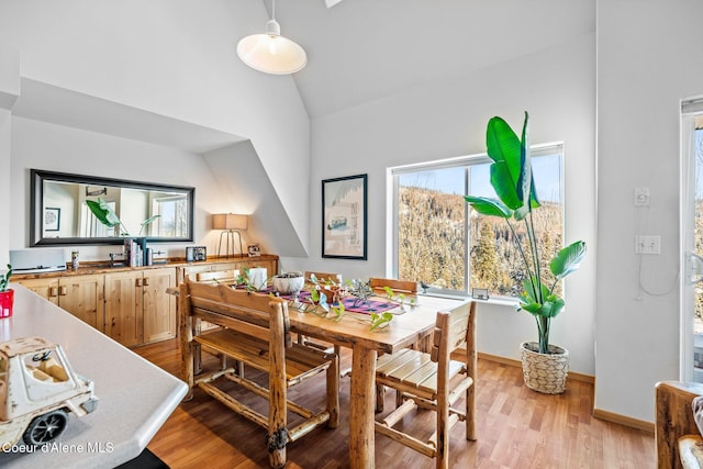 dining room with lofted ceiling and light hardwood / wood-style floors