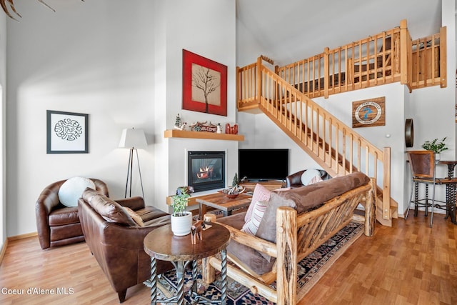 living room with light hardwood / wood-style flooring and a high ceiling