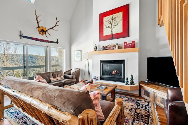 living room featuring high vaulted ceiling, a healthy amount of sunlight, and hardwood / wood-style flooring