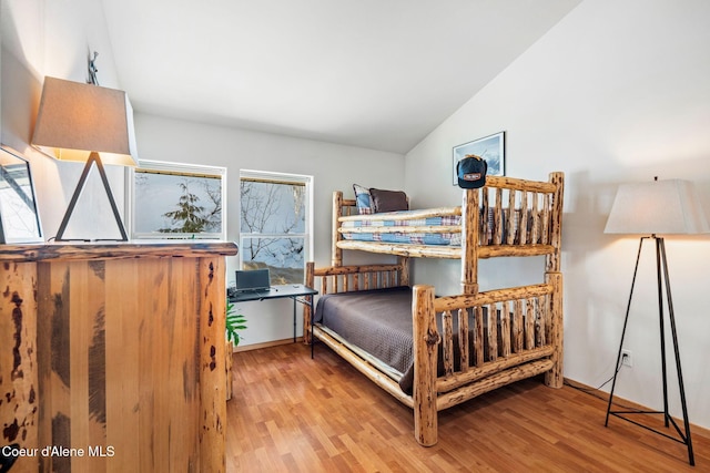 bedroom featuring light hardwood / wood-style floors and lofted ceiling