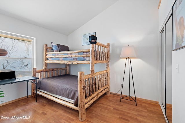 bedroom with lofted ceiling and wood-type flooring