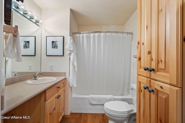 full bathroom featuring hardwood / wood-style floors, toilet, vanity, and shower / tub combo with curtain