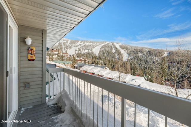 snow covered back of property featuring a mountain view